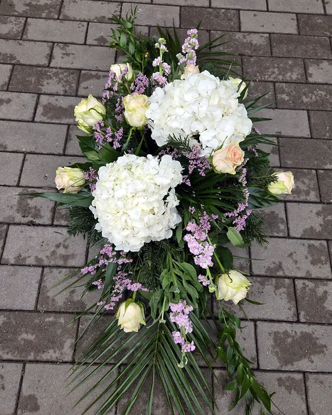 Wiązanka na wieko trumny Łąka: Podłużna wiązanka z białej hortensji, kremowych róż i fioletowego limonium. Kwiaciarnia Bukieteria Gorzów Wielkopolski
